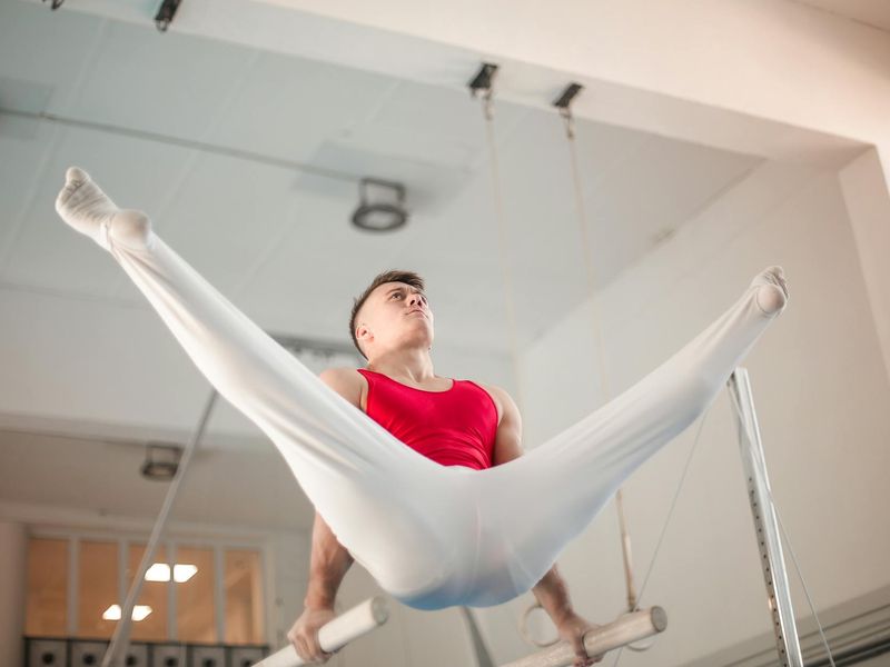 Man performing a controlled bodyweight exercise in a minimalist gym.
